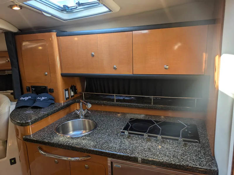 Slide: The Image of 2008 Chaparral 330 Signature yacht kitchen with granite countertops and wooden cabinets. - 15