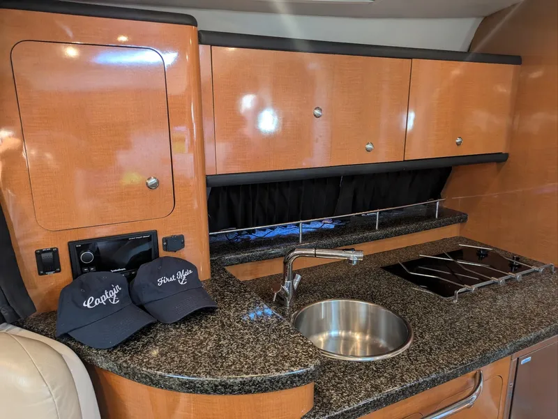 Slide: The Image of 2008 Chaparral 330 Signature yacht kitchen with granite countertops and wooden cabinets. - 16