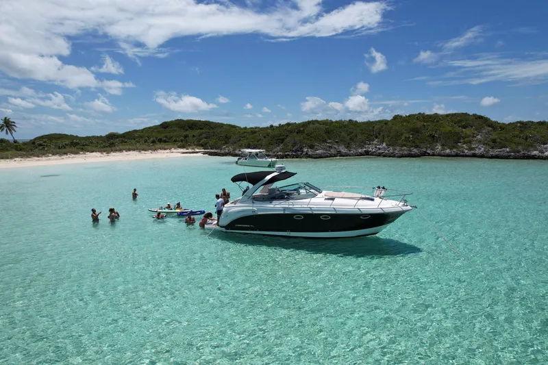Slide: The Image of 2008 Chaparral 330 Signature yacht anchored in clear turquoise waters near a tropical beach. - 2
