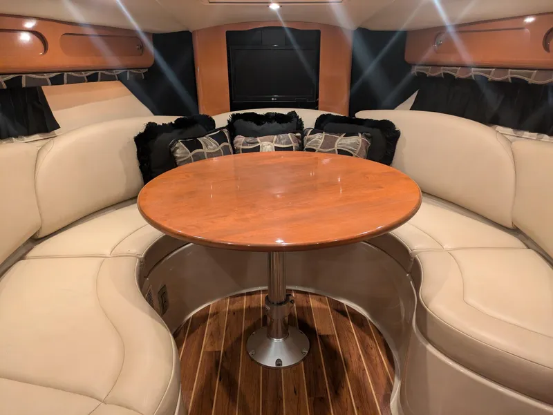 Slide: The Image of 2008 Chaparral 330 Signature interior with curved seating and wooden table. - 8