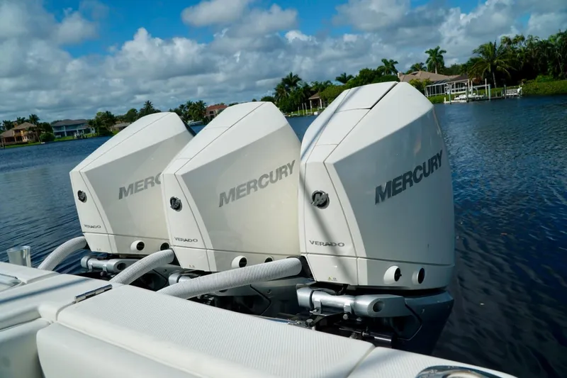 Slide: The Image of Triple Mercury Verado engines on a 2017 SeaVee 34Z boat, docked on a serene lake. - 11