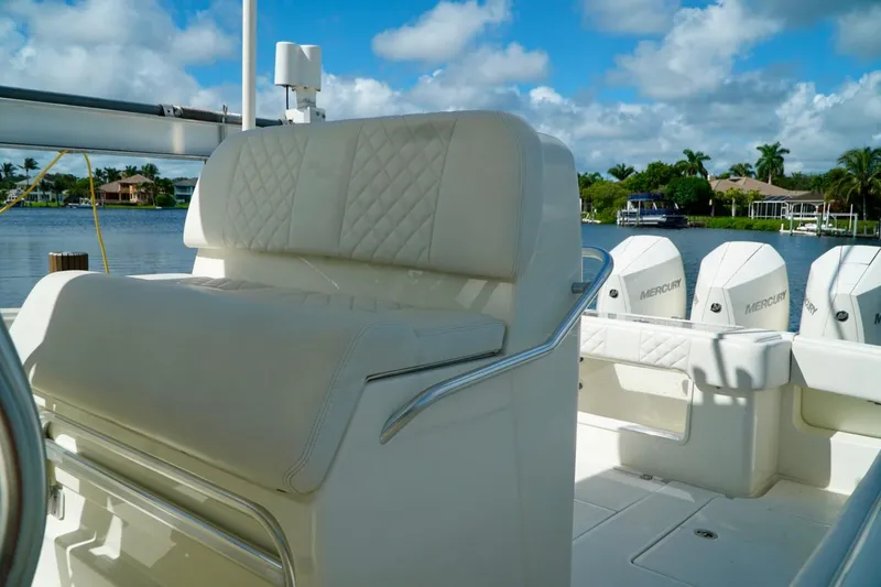 Slide: The Image of 2017 SeaVee 34Z boat interior with luxurious seating and Mercury engines, docked by a scenic waterfront. - 15