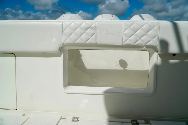 Slide: The Image of 2017 SeaVee 34Z boat interior with white cushioned seating and storage compartment. - 16