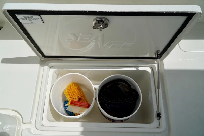 Slide: The Image of 2017 SeaVee 34Z storage compartment with cleaning supplies and rope. - 26