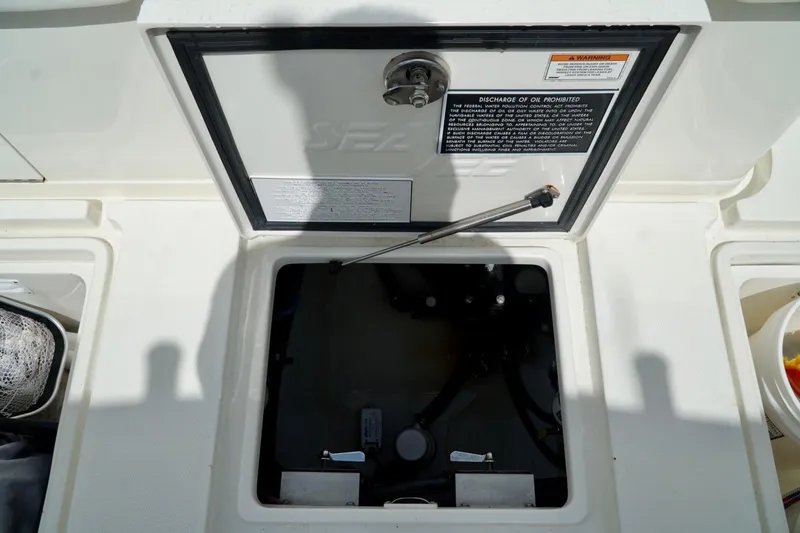 Slide: The Image of 2017 SeaVee 34Z boat compartment with open hatch and warning labels. - 37