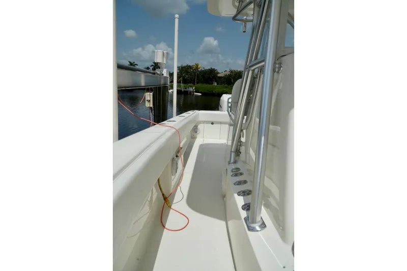 Slide: The Image of 2017 SeaVee 34Z boat deck with rod holders, docked by a calm waterway. - 57