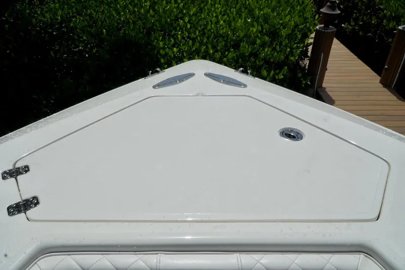 Slide: The Image of 2017 SeaVee 34Z boat deck with storage hatch, surrounded by lush greenery. - 67