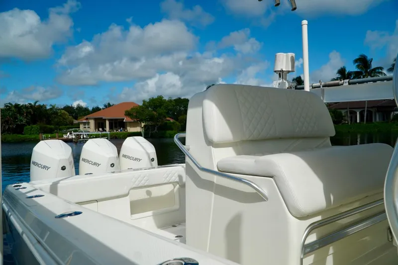 Slide: The Image of 2017 SeaVee 34Z boat with Mercury engines, luxurious seating, and scenic waterfront view. - 7