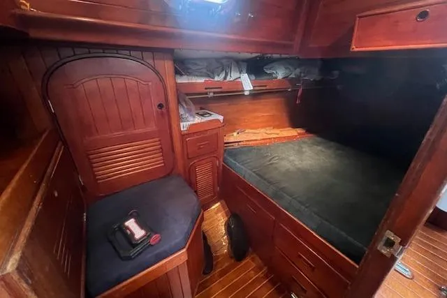 Slide: The Image of Cozy cabin interior of 1983 Baba 40 sailboat with wooden furnishings and bunk bed. - 11