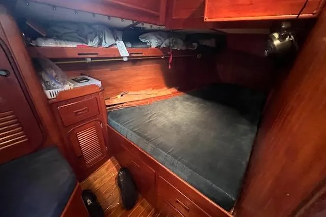 Slide: The Image of Cozy cabin interior of 1983 Baba 40 sailboat with wooden furnishings and bedding. - 12
