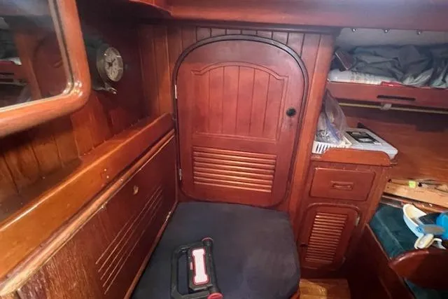 Slide: The Image of Interior of a 1983 Baba 40 sailboat with wooden cabinetry and seating area. - 13