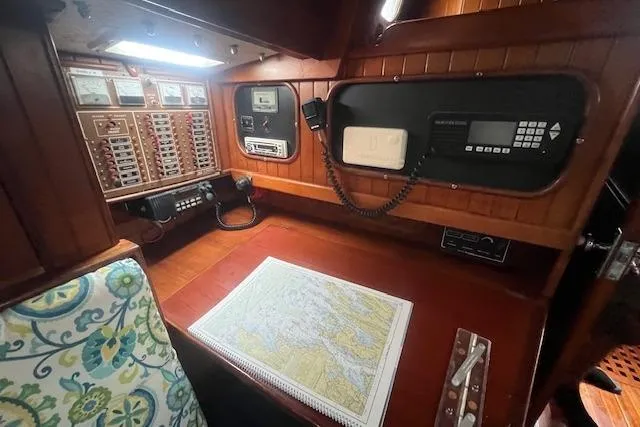 Slide: The Image of Navigation station in a 1983 Baba 40 sailboat with map, control panels, and wooden interior. - 15