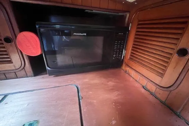 Slide: The Image of Frigidaire microwave in a 1983 Baba 40 boat's wooden interior kitchen. - 17