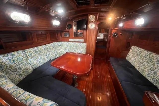 Slide: The Image of Interior of a 1983 Baba 40 sailboat with wooden finishes and cozy seating area. - 2