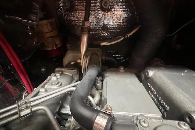 Slide: The Image of Engine compartment of a 1983 Baba 40 sailboat, showcasing mechanical components and wiring. - 23