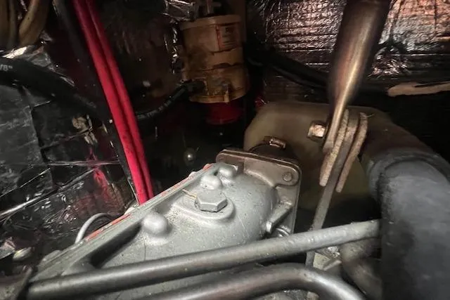 Slide: The Image of Engine compartment of a 1983 Baba 40 sailboat, showing mechanical components and wiring. - 26