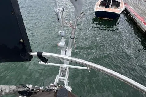 Slide: The Image of Bow view of 1983 Baba 40 sailboat docked near a small wooden boat. - 28