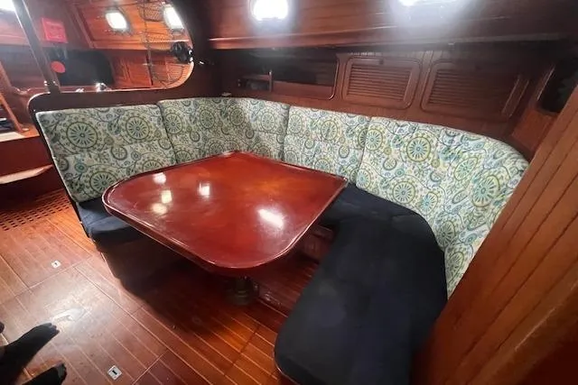 Slide: The Image of Cozy 1983 Baba 40 sailboat interior with wooden table and patterned seating. - 3