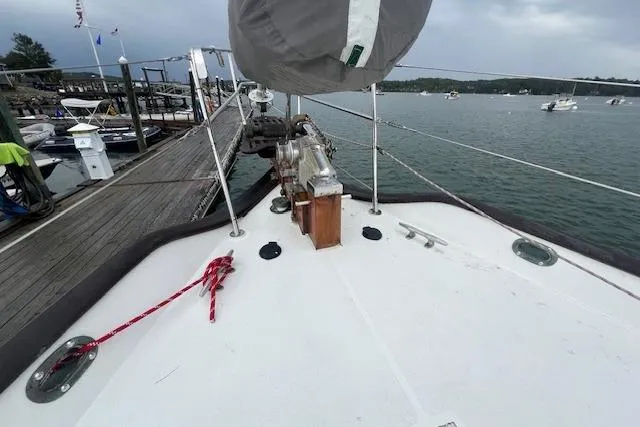 Slide: The Image of 1983 Baba 40 sailboat deck at marina, featuring mooring lines and calm waters. - 32