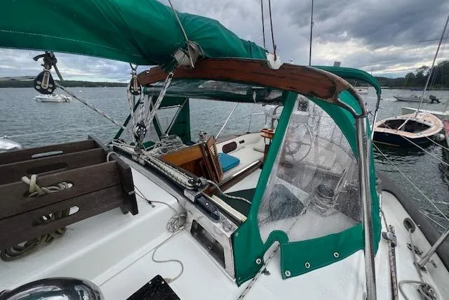 Slide: The Image of 1983 Baba 40 sailboat cockpit with green canopy, moored on a cloudy day. - 36