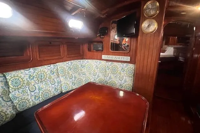 Slide: The Image of Cozy 1983 Baba 40 sailboat interior with patterned seating and wooden table. - 4