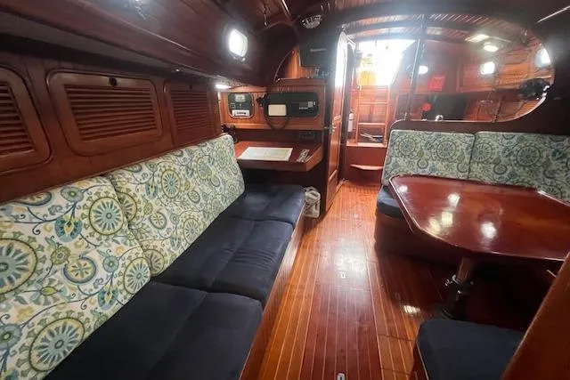 Slide: The Image of Interior of a 1983 Baba 40 sailboat with wooden furnishings and patterned cushions. - 6