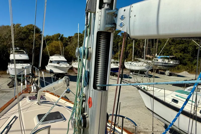 Slide: The Image of 2005 Island Packet 485 sailboat in a boatyard with other vessels, surrounded by trees. - 15