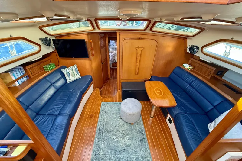 Slide: The Image of Luxurious 2005 Island Packet 485 yacht interior with blue leather seating and wooden accents. - 16