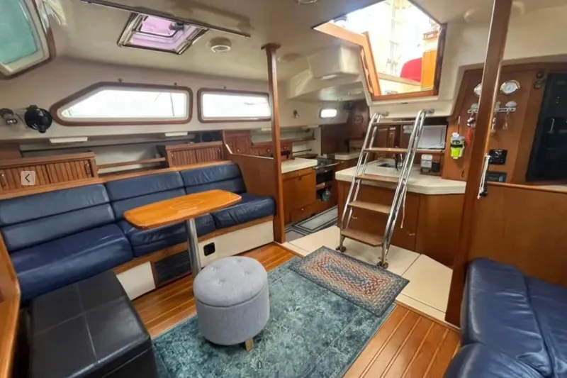 Slide: The Image of Interior of 2005 Island Packet 485 yacht with blue seating and wooden accents. - 18