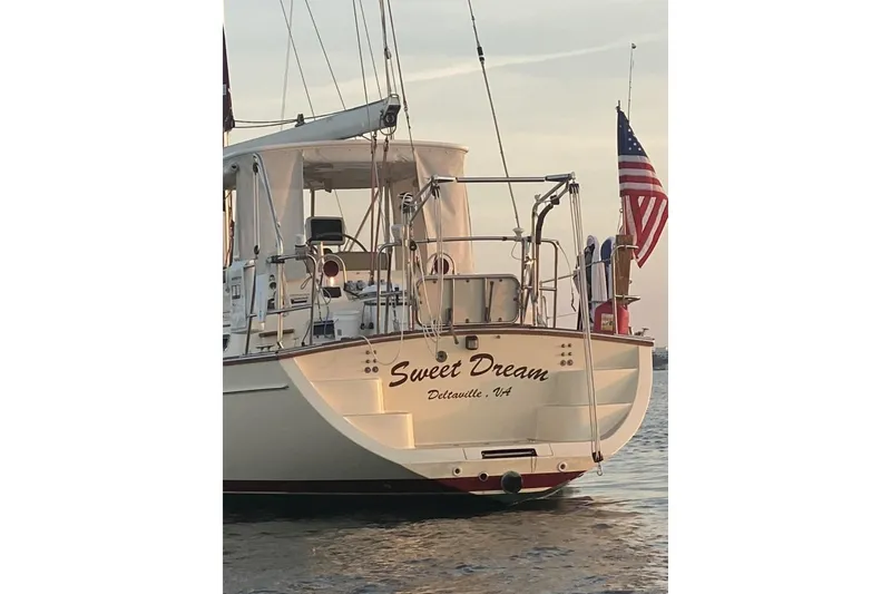 Slide: The Image of Island Packet 485 sailboat "Sweet Dream" on water, displaying American flag, 2005 model. - 2