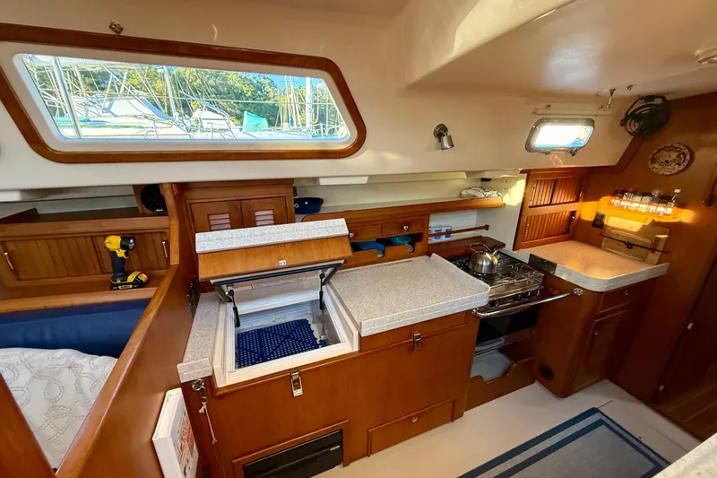 Slide: The Image of 2005 Island Packet 485 yacht interior with kitchen, wooden cabinetry, and appliances. - 21