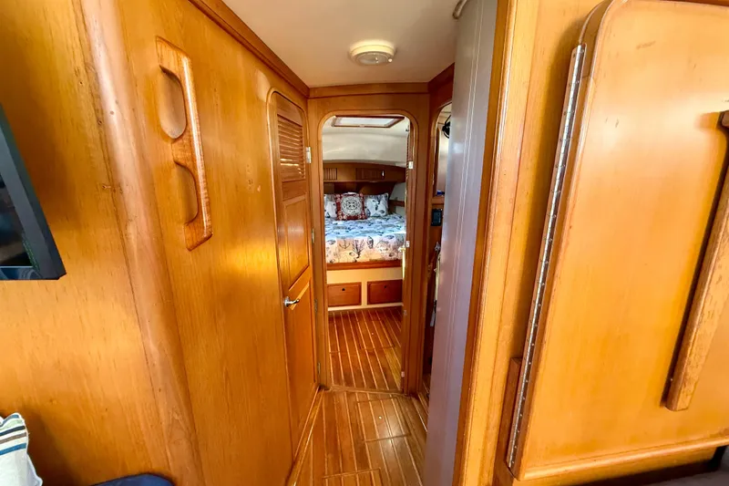 Slide: The Image of Interior view of 2005 Island Packet 485 yacht, featuring wooden paneling and cozy cabin. - 26