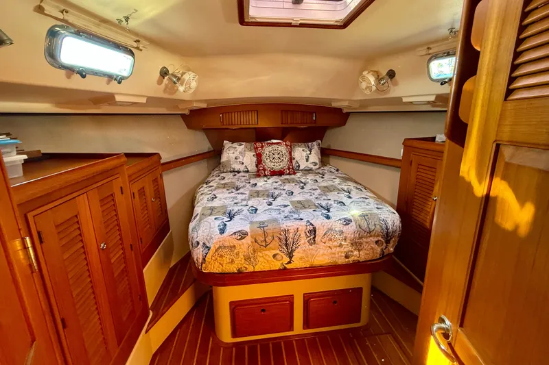 Slide: The Image of Luxurious 2005 Island Packet 485 yacht cabin with cozy bed and wooden cabinetry. - 27