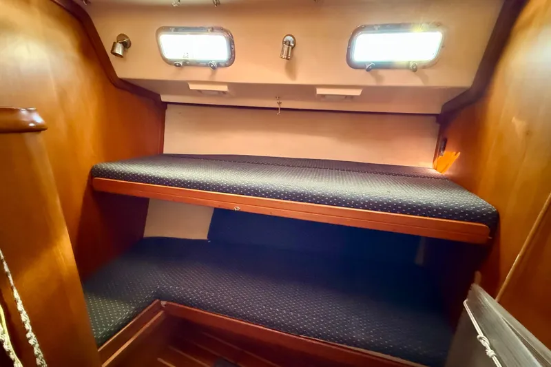 Slide: The Image of 2005 Island Packet 485 yacht cabin with wooden interior and bunk beds. - 29