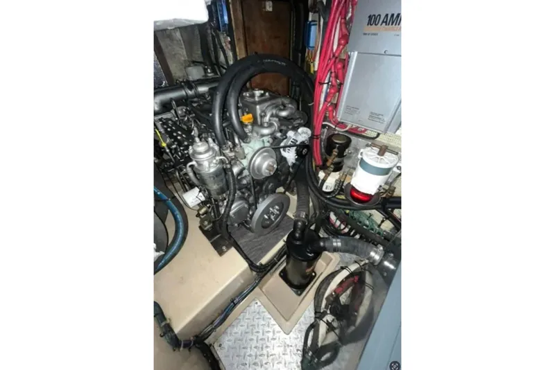 Slide: The Image of Engine room of 2005 Island Packet 485 sailboat, showcasing mechanical components and wiring. - 31