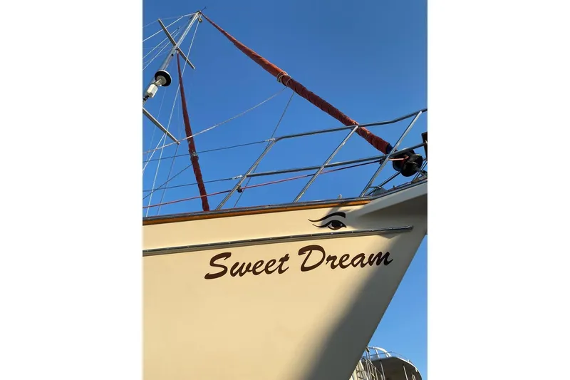 Slide: The Image of Island Packet 485 sailboat, 2005 model, named "Sweet Dream" against clear blue sky. - 34