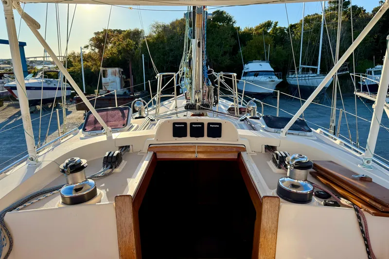 Slide: The Image of 2005 Island Packet 485 sailboat cockpit with winches and navigation equipment, docked near other boats. - 9