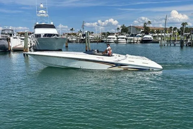 Slide: The Image of 1998 Fountain 35 Lightning boat cruising in a marina with clear blue water. - 0