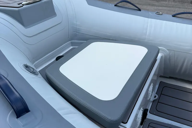 Slide: The Image of 2025 Highfield CL310 FCT boat interior with cushioned seating and storage compartment. - 5