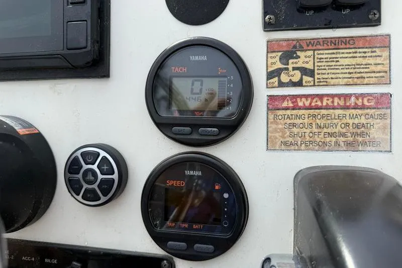 Slide: The Image of Control panel of a 2013 Hewes Redfisher 18 boat with Yamaha gauges and warning labels. - 14