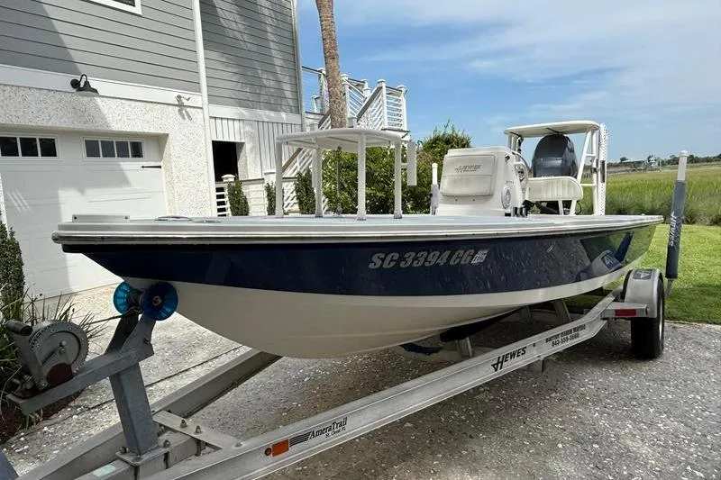 Slide: The Image of 2013 Hewes Redfisher 18 boat on trailer, parked near a house. - 4