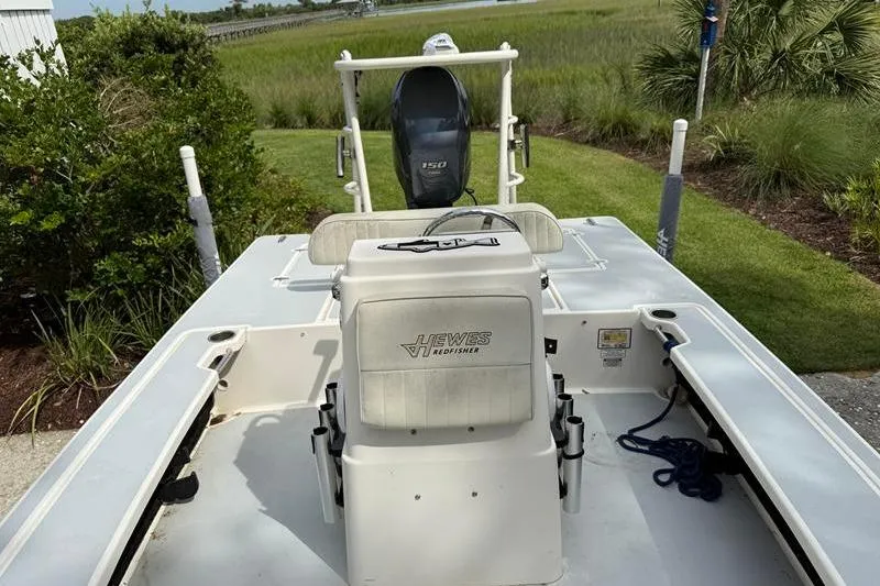 Slide: The Image of 2013 Hewes Redfisher 18 boat with Yamaha 150 engine, parked near lush greenery. - 8