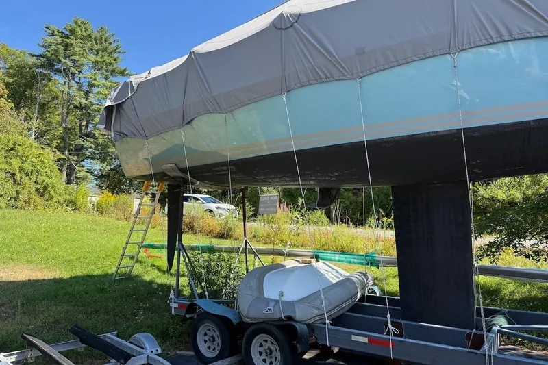 Slide: The Image of Covered 2007 Hallett 33 boat on trailer, surrounded by greenery and clear blue sky. - 10