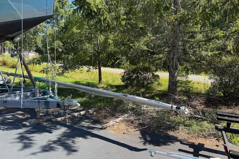 Slide: The Image of 2007 Hallett 33 boat on trailer, surrounded by trees and greenery. - 11