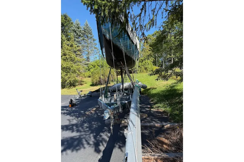 Slide: The Image of 2007 Hallett 33 boat on trailer, surrounded by trees and clear blue sky. - 26