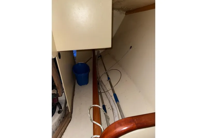 Slide: The Image of Interior of a 2007 Hallett 33 boat showing storage area with a blue bucket. - 43