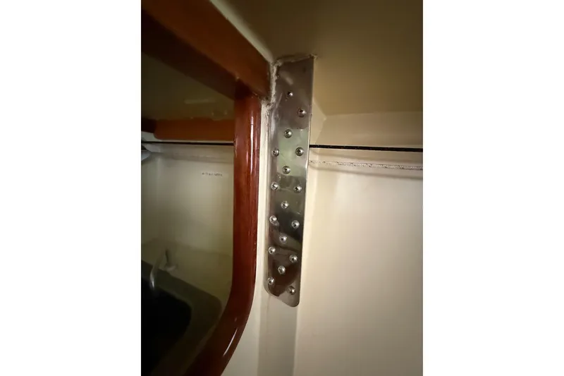 Slide: The Image of Interior detail of a 2007 Hallett 33 boat, featuring a metal bracket and wooden trim. - 48