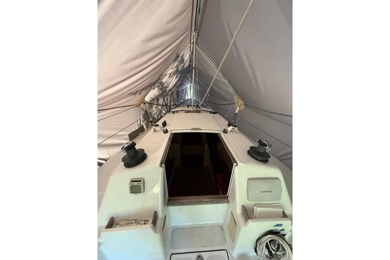 Slide: The Image of 2007 Hallett 33 boat under cover, showing deck and cockpit area. - 57