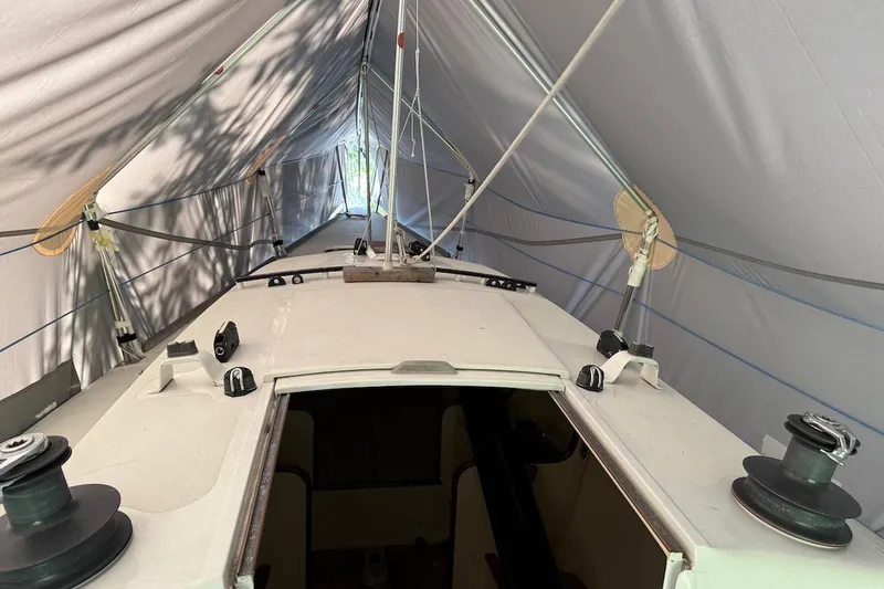 Slide: The Image of 2007 Hallett 33 boat under protective cover, showing deck and rigging. - 58