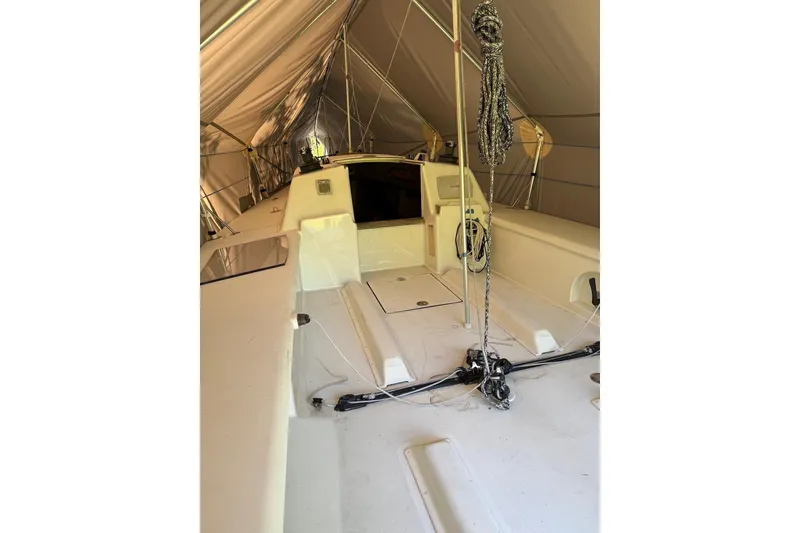 Slide: The Image of 2007 Hallett 33 boat interior under a protective canopy, showcasing deck and rigging. - 64